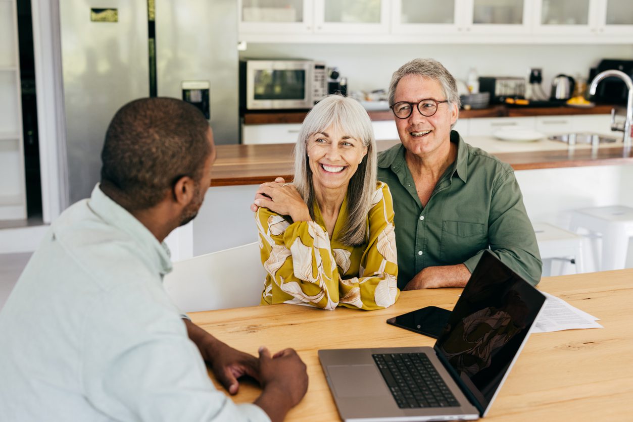 Senior couple reviewing real estate options with an agent to rightsize their home and optimize their property wealth.